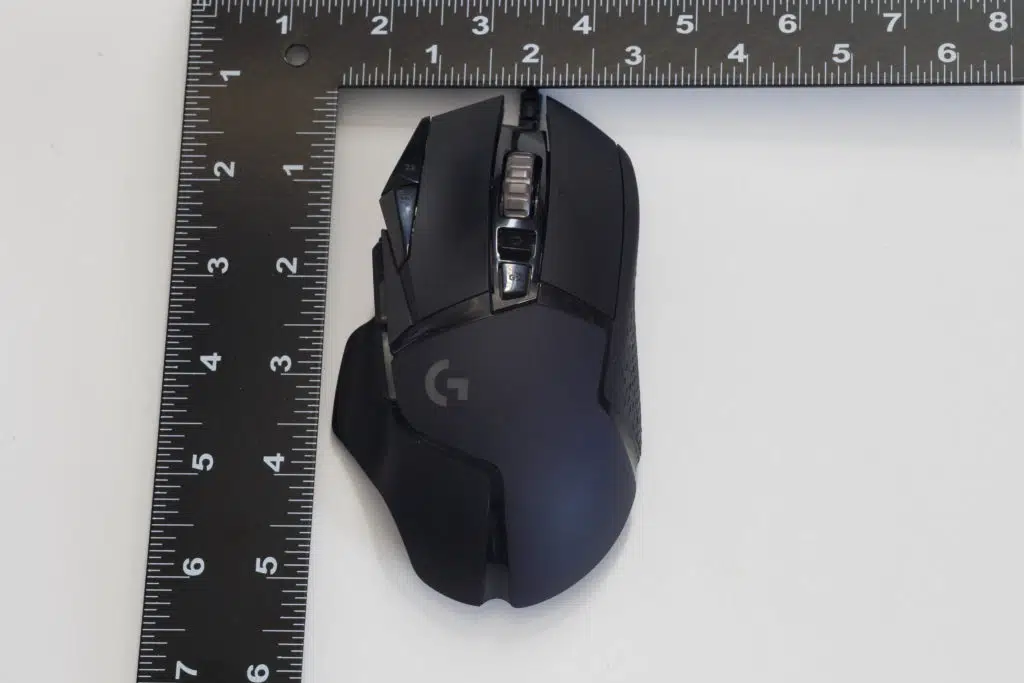 Logitech G502 HERO High Performance Gaming Mouse next to ruler showing size